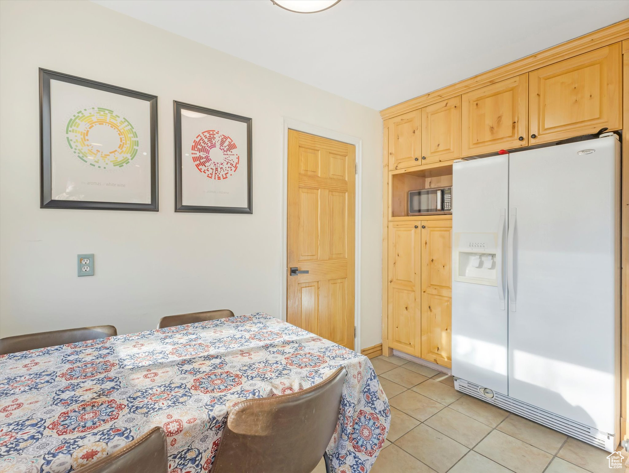 Kitchen featuring light tile floors and fridge with ice dispenser