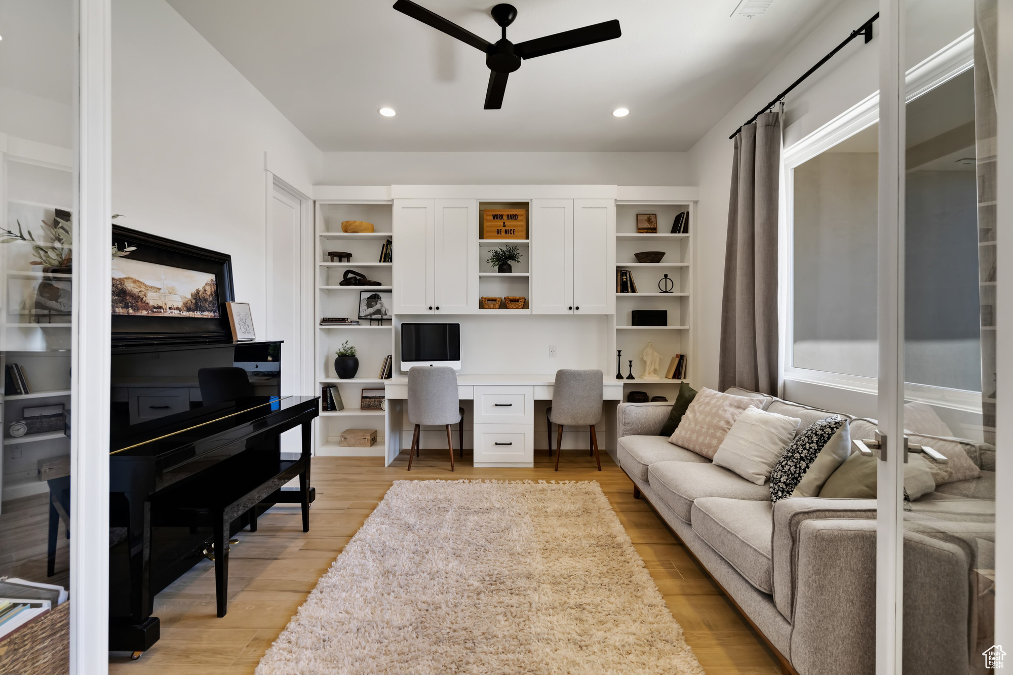 Office area with ceiling fan, light hardwood / wood-style floors, and built in desk