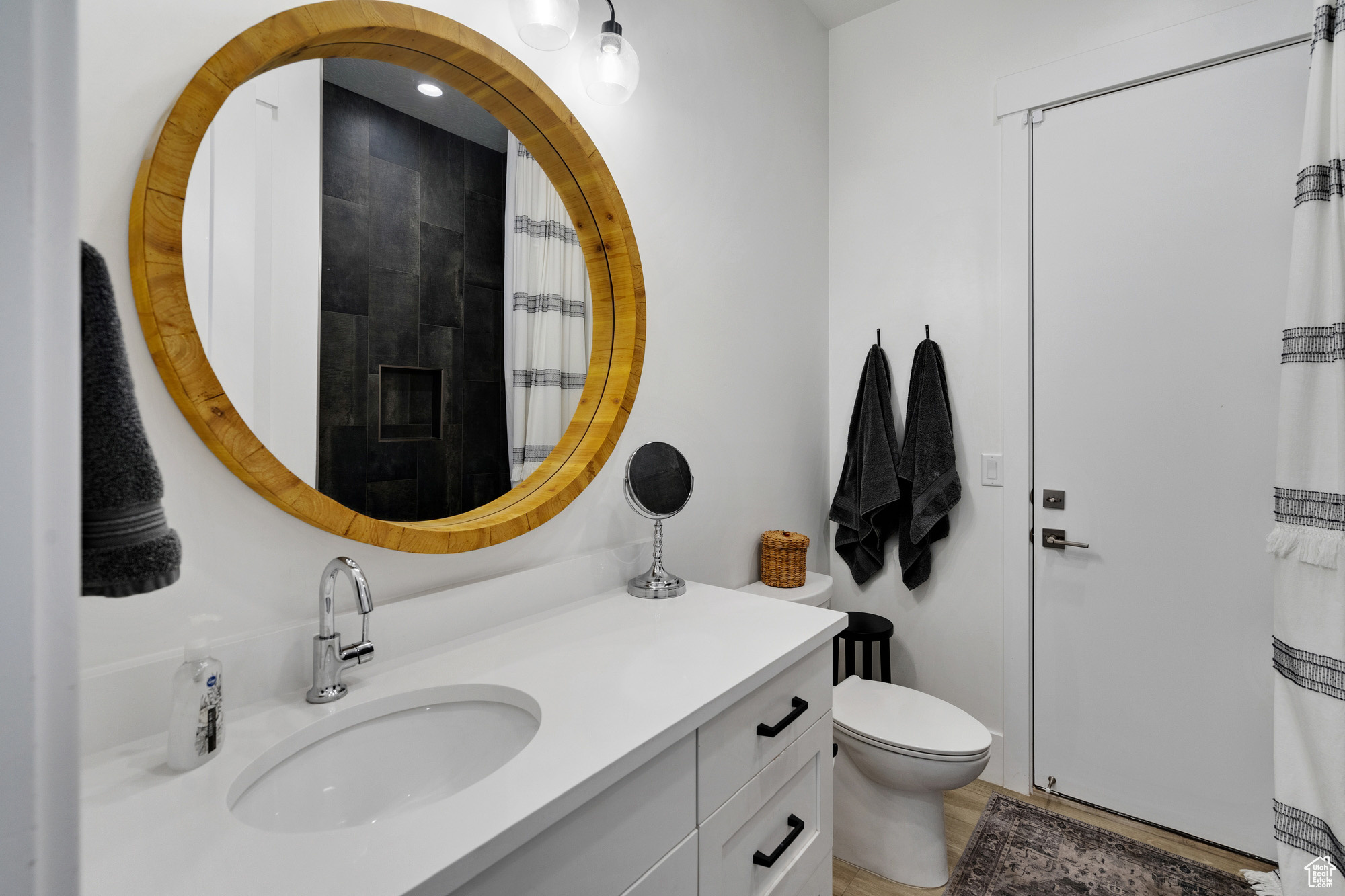 Bathroom featuring toilet, vanity, and walk in shower