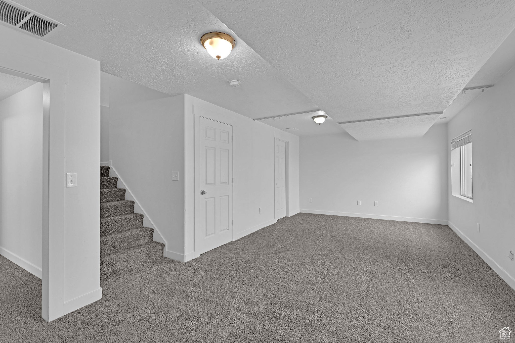 Basement with carpet floors and a textured ceiling