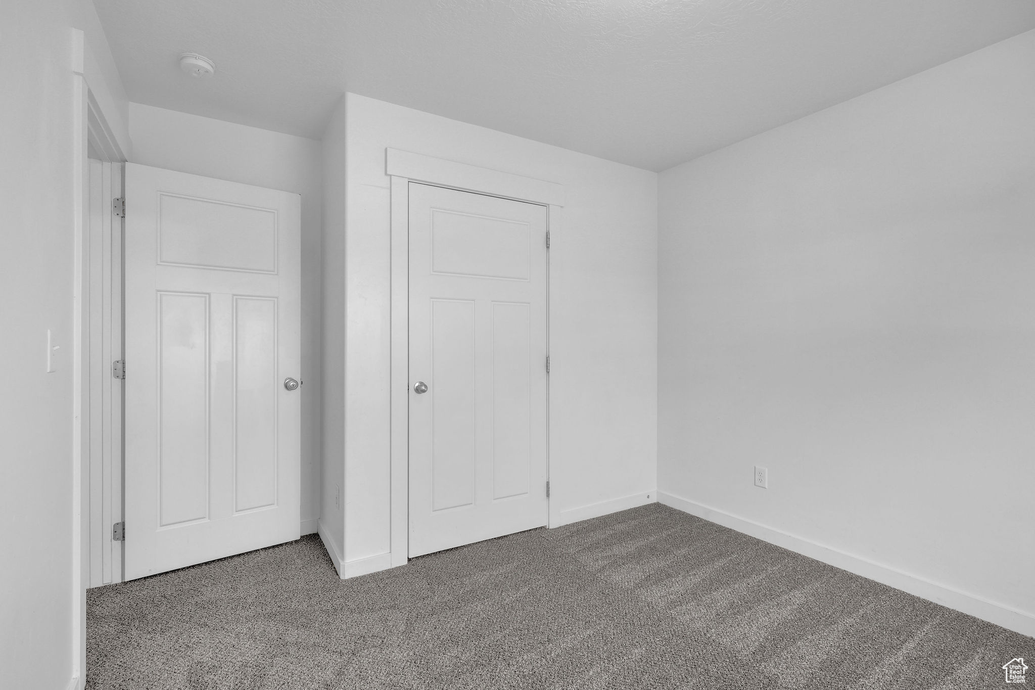 Unfurnished bedroom with a closet and dark carpet