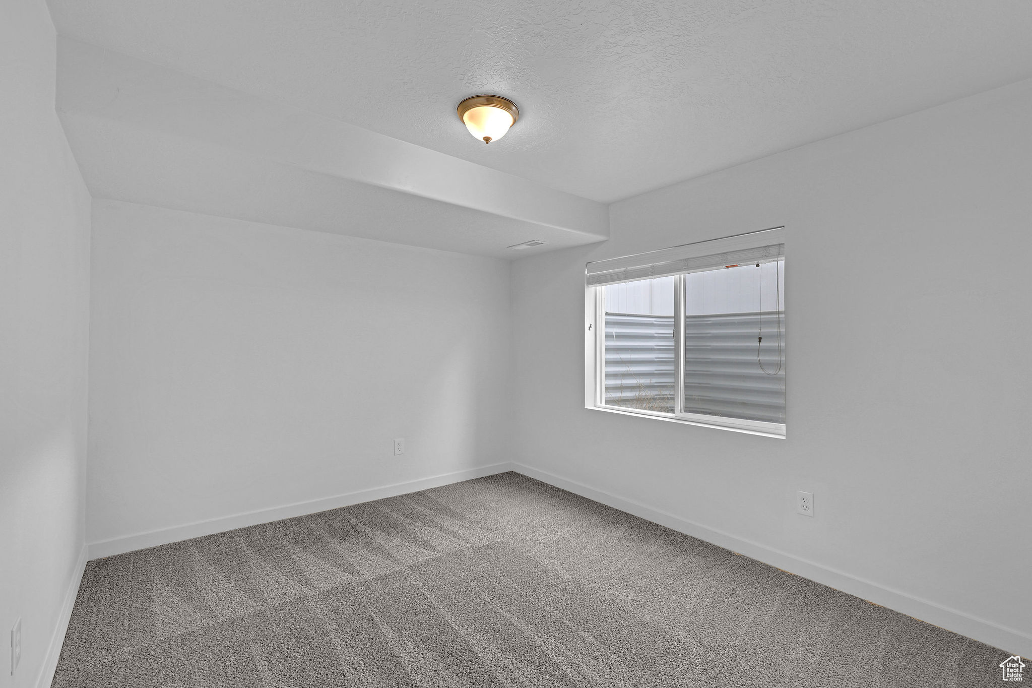 Carpeted empty room with a textured ceiling