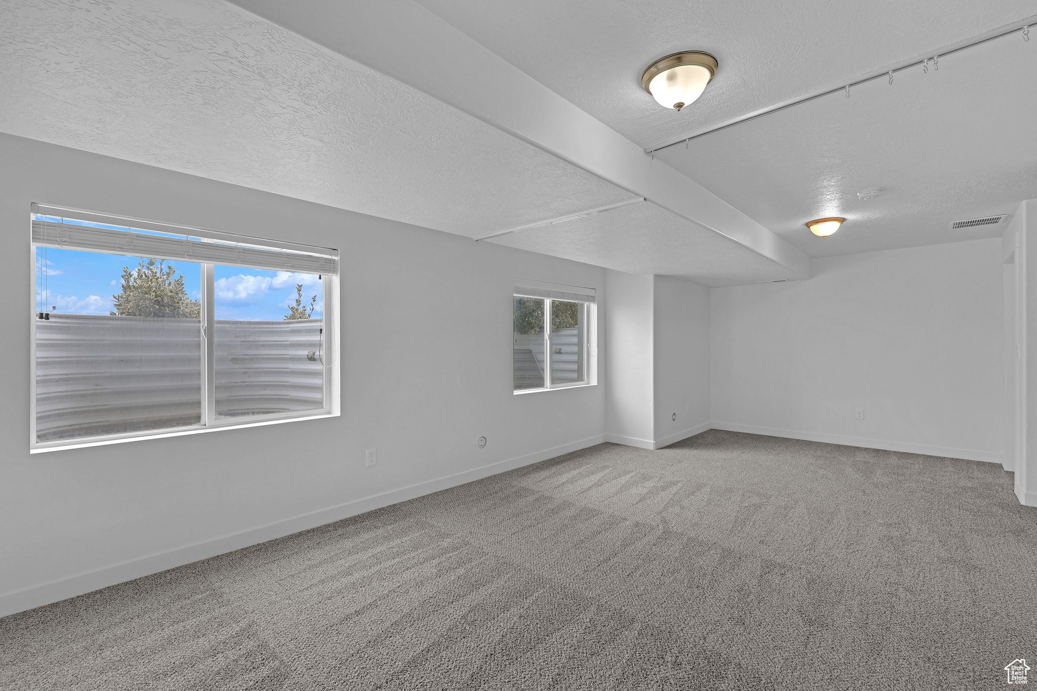 Unfurnished room featuring a textured ceiling and carpet floors