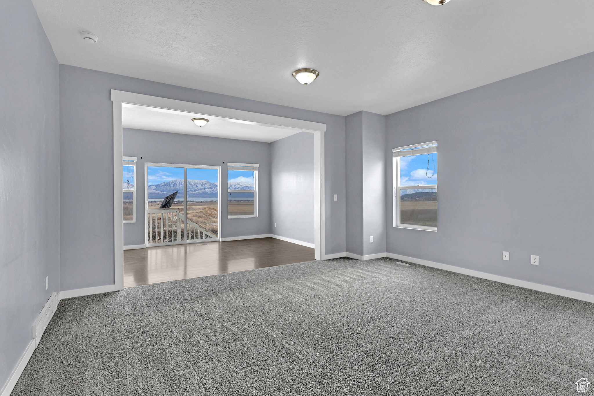 Carpeted spare room with a textured ceiling