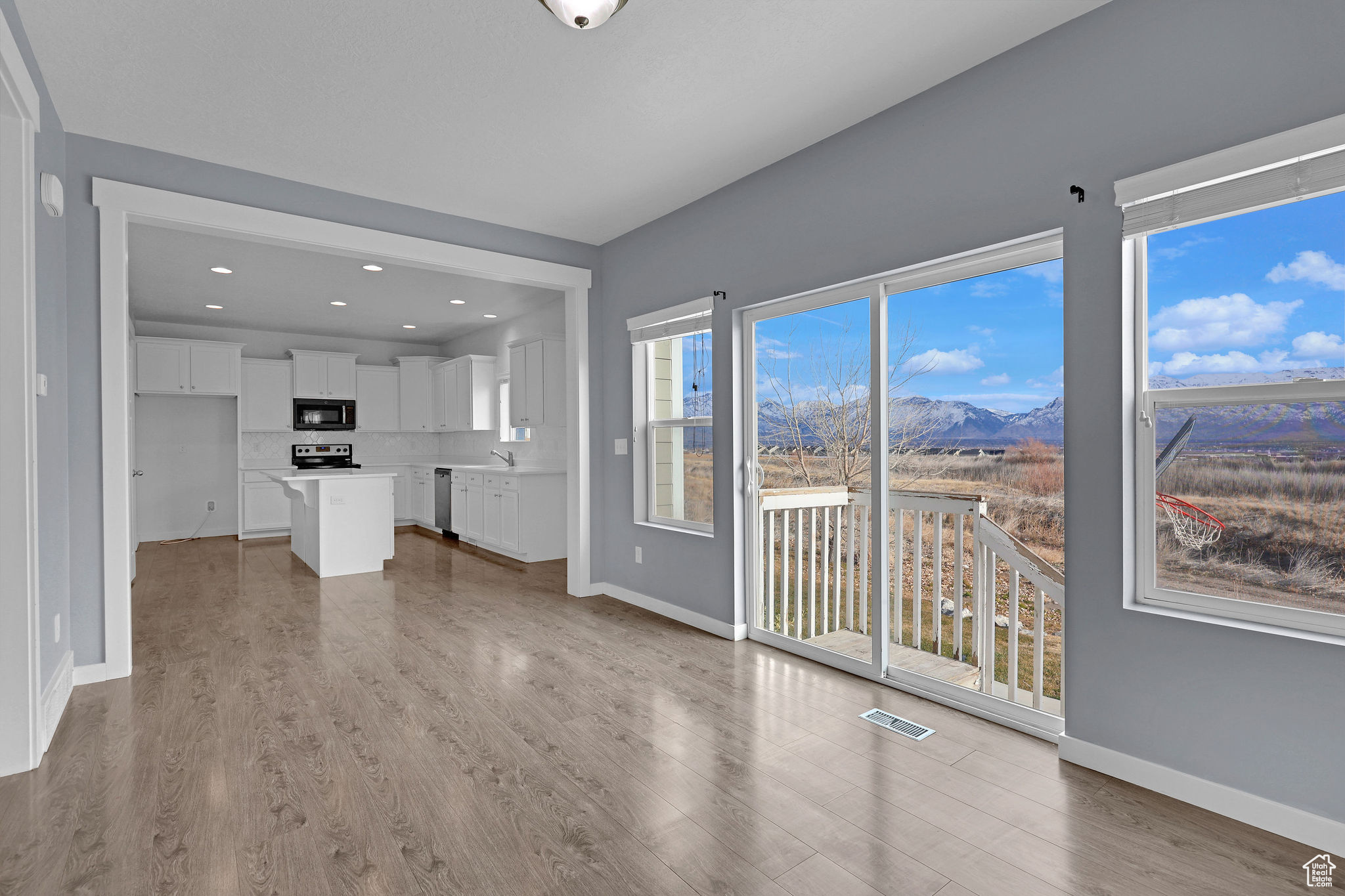 Unfurnished living room with a mountain view, sink, and wood-type flooring