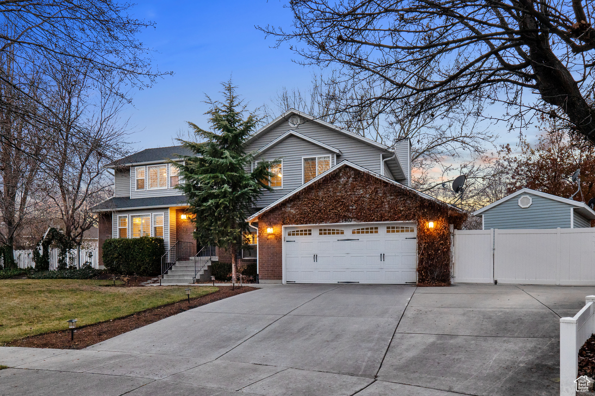 Front of property with a garage and a lawn