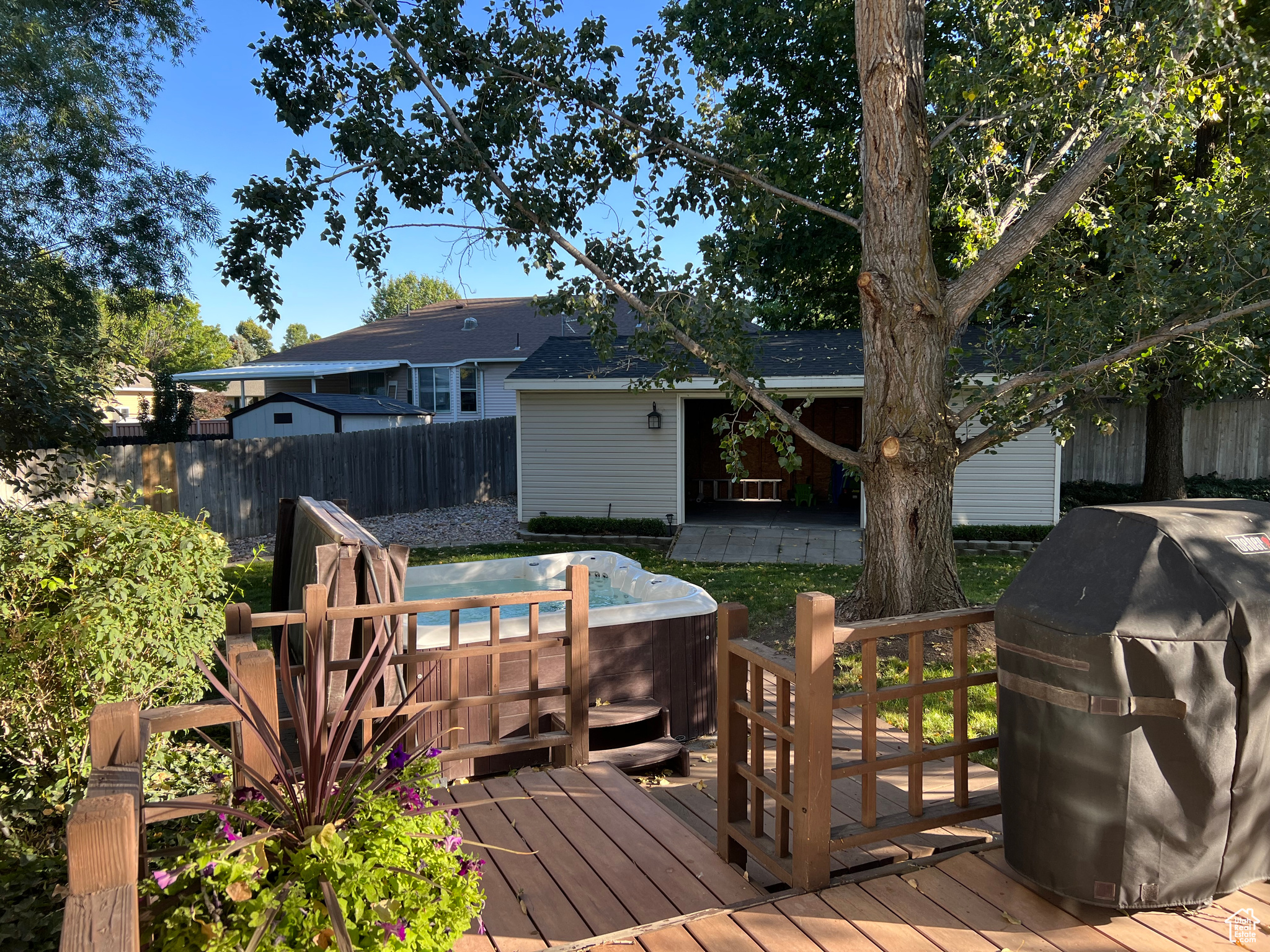 Wooden terrace featuring area for grilling and a hot tub