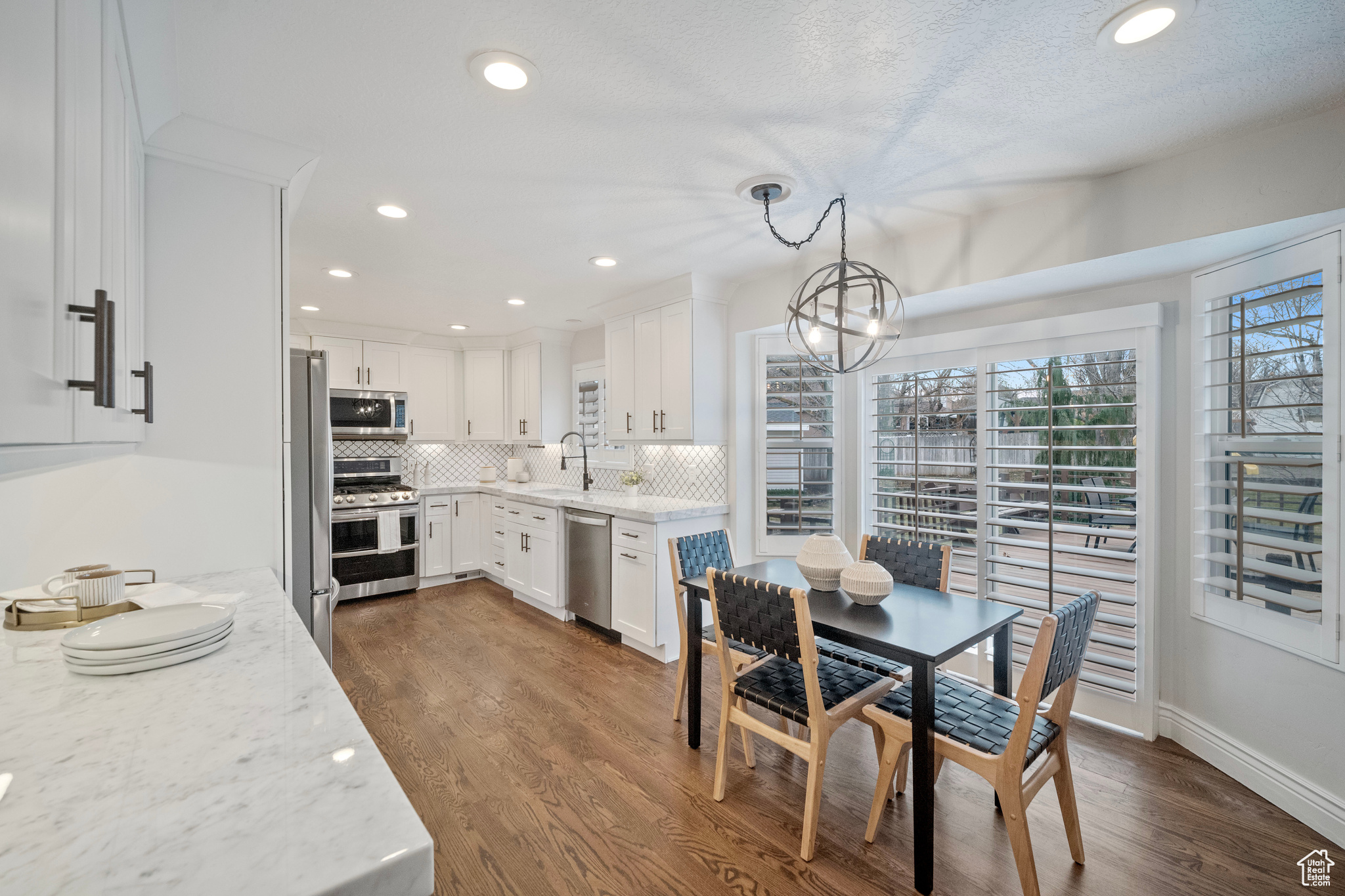 Dining room featuring a textured ceiling, dark hardwood / wood-style flooring, sink, and an inviting chandelier