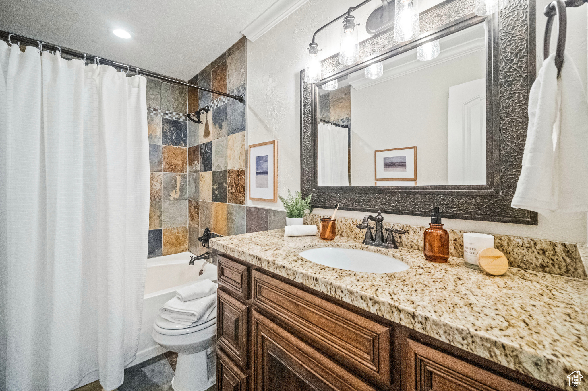 Full bathroom featuring shower / bath combo, vanity, toilet, and crown molding