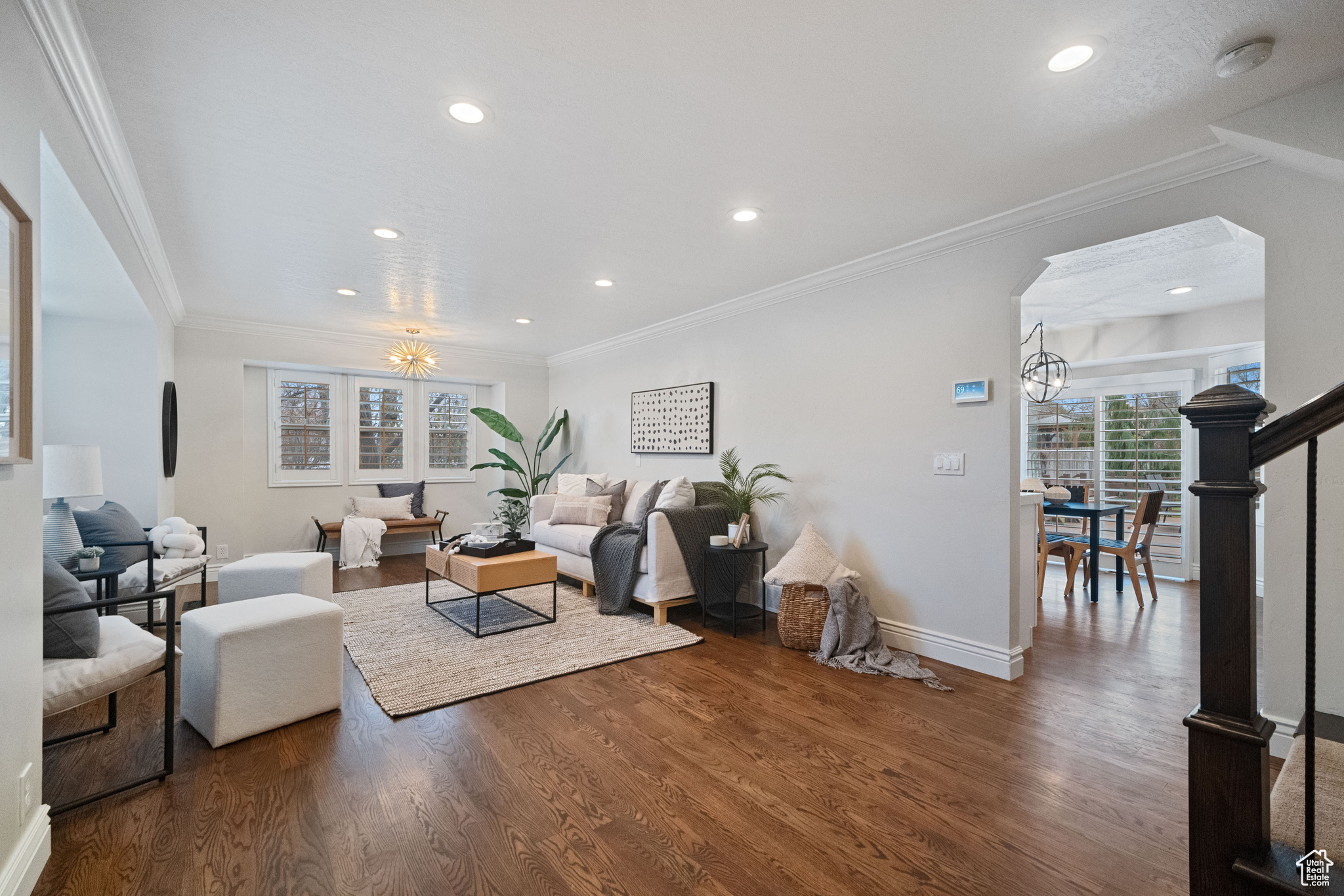 Living room featuring dark hardwood / wood-style flooring, a chandelier, and ornamental molding