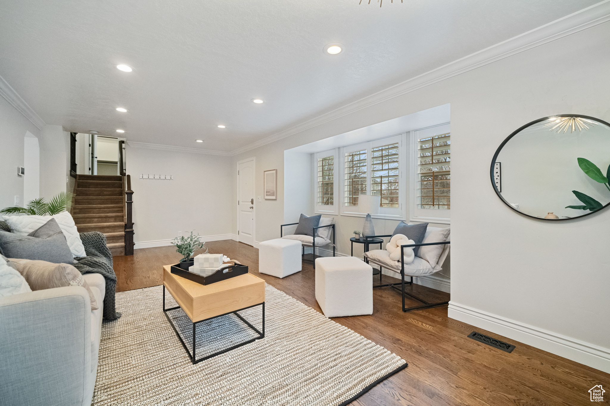 Living room with hardwood / wood-style floors and crown molding