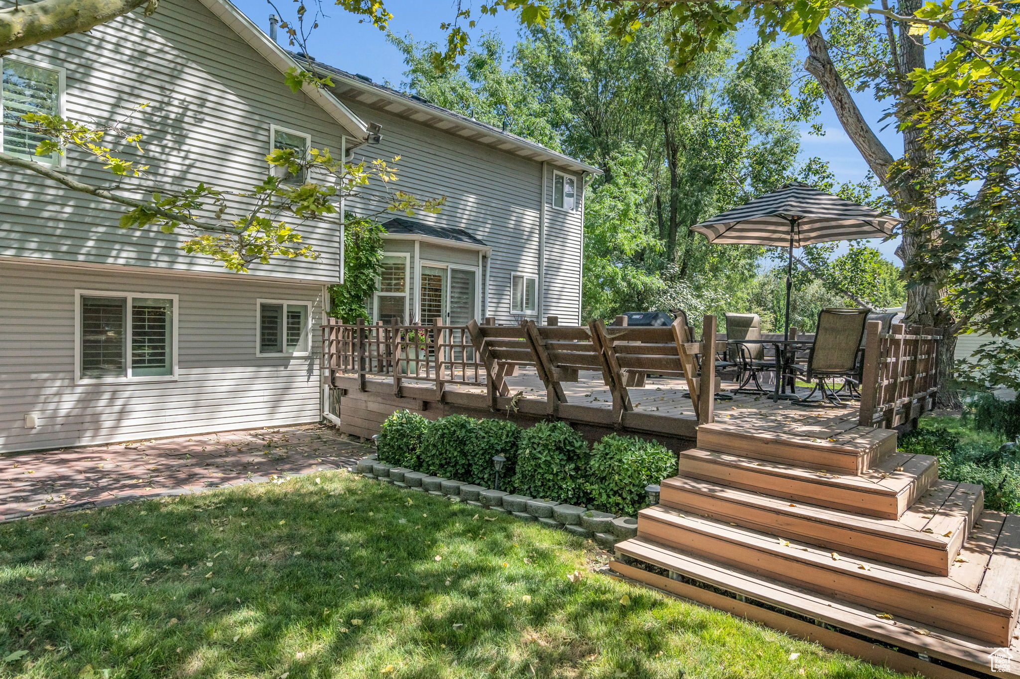 Back of property with a yard and a wooden deck