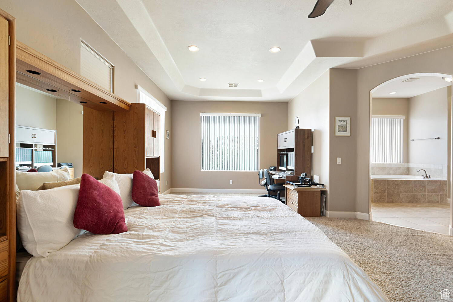 Carpeted bedroom with ensuite bathroom and a raised ceiling