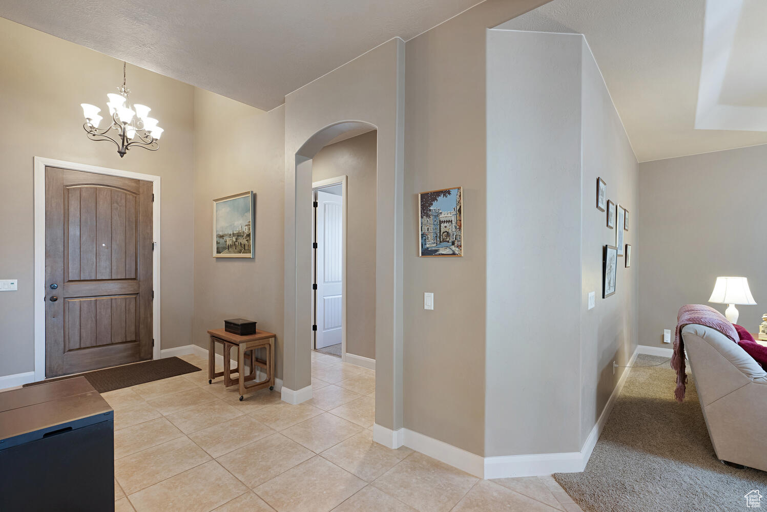 Tiled foyer with a chandelier