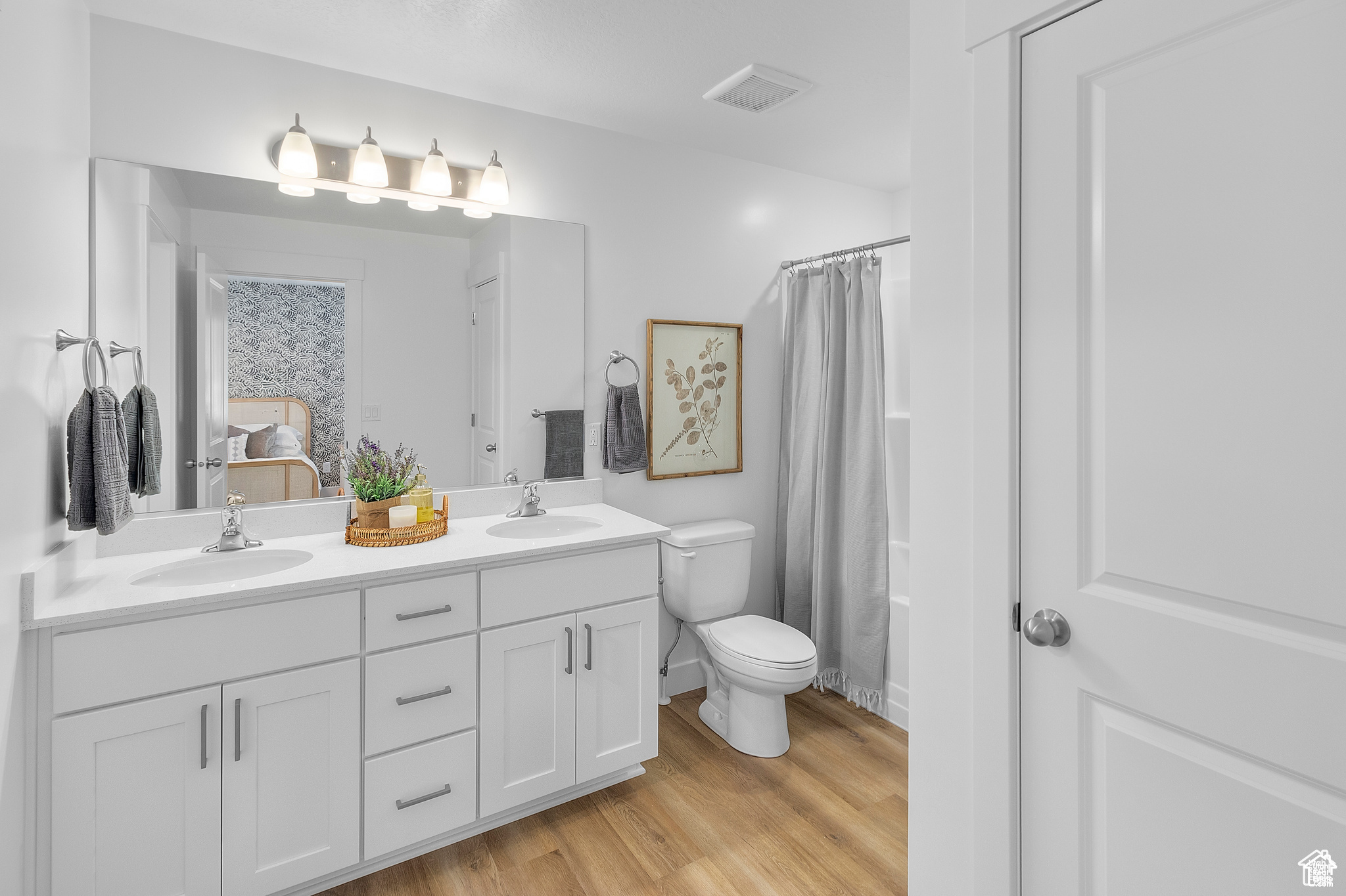 Full bathroom with vanity, hardwood / wood-style flooring, toilet, and shower / tub combo with curtain