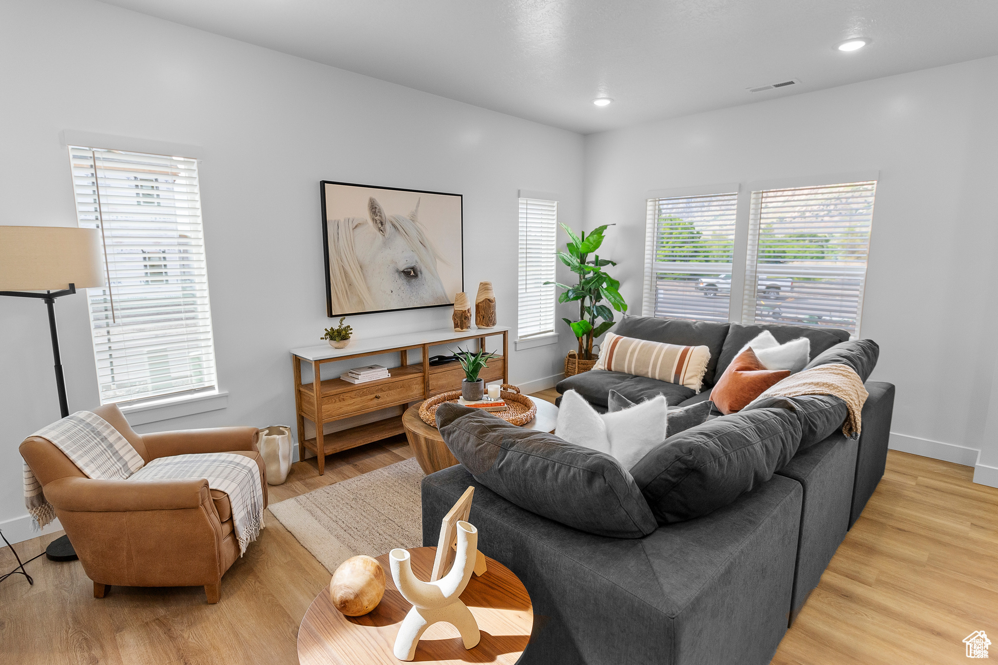 Living room with light hardwood / wood-style flooring and a healthy amount of sunlight