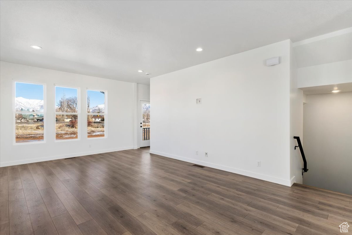 Empty room with dark hardwood / wood-style flooring