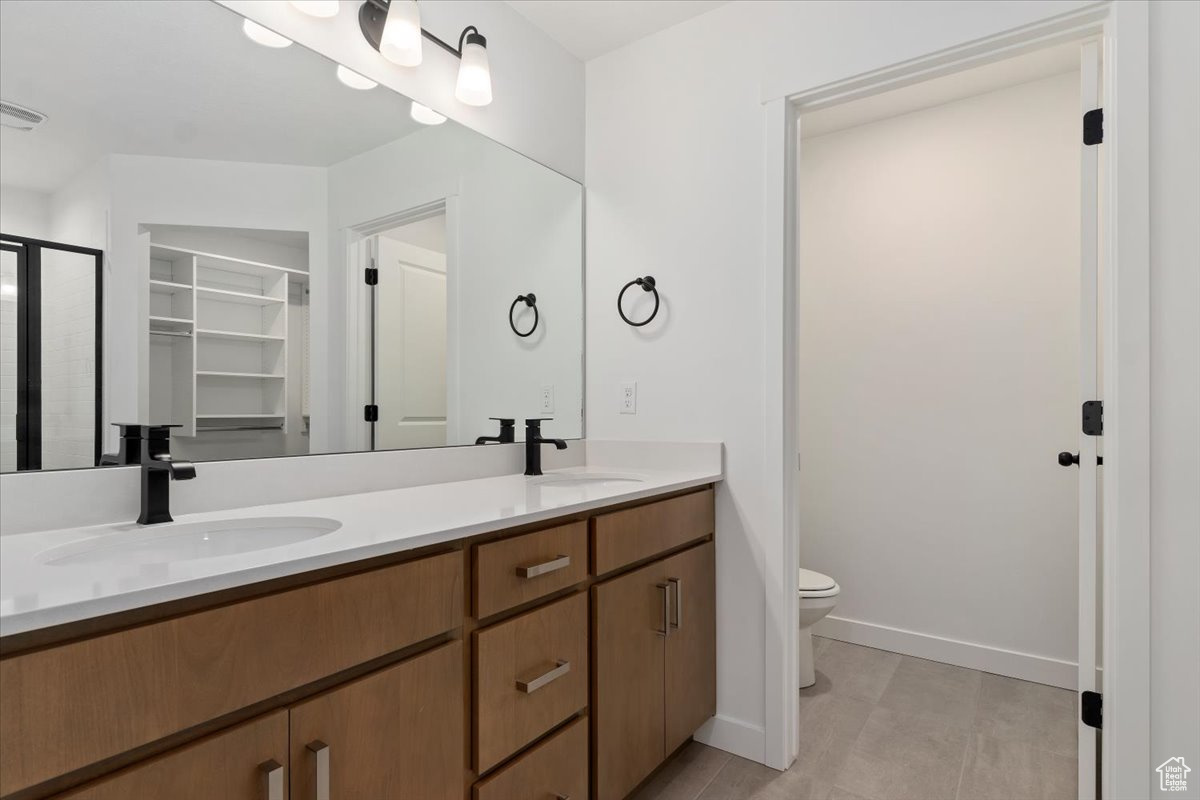 Bathroom with tile patterned floors, vanity, and toilet