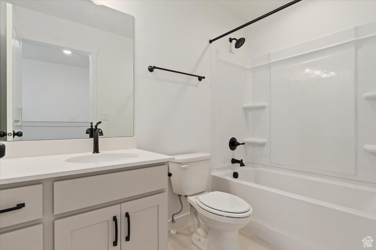 Full bathroom featuring tile patterned flooring, vanity,  shower combination, and toilet