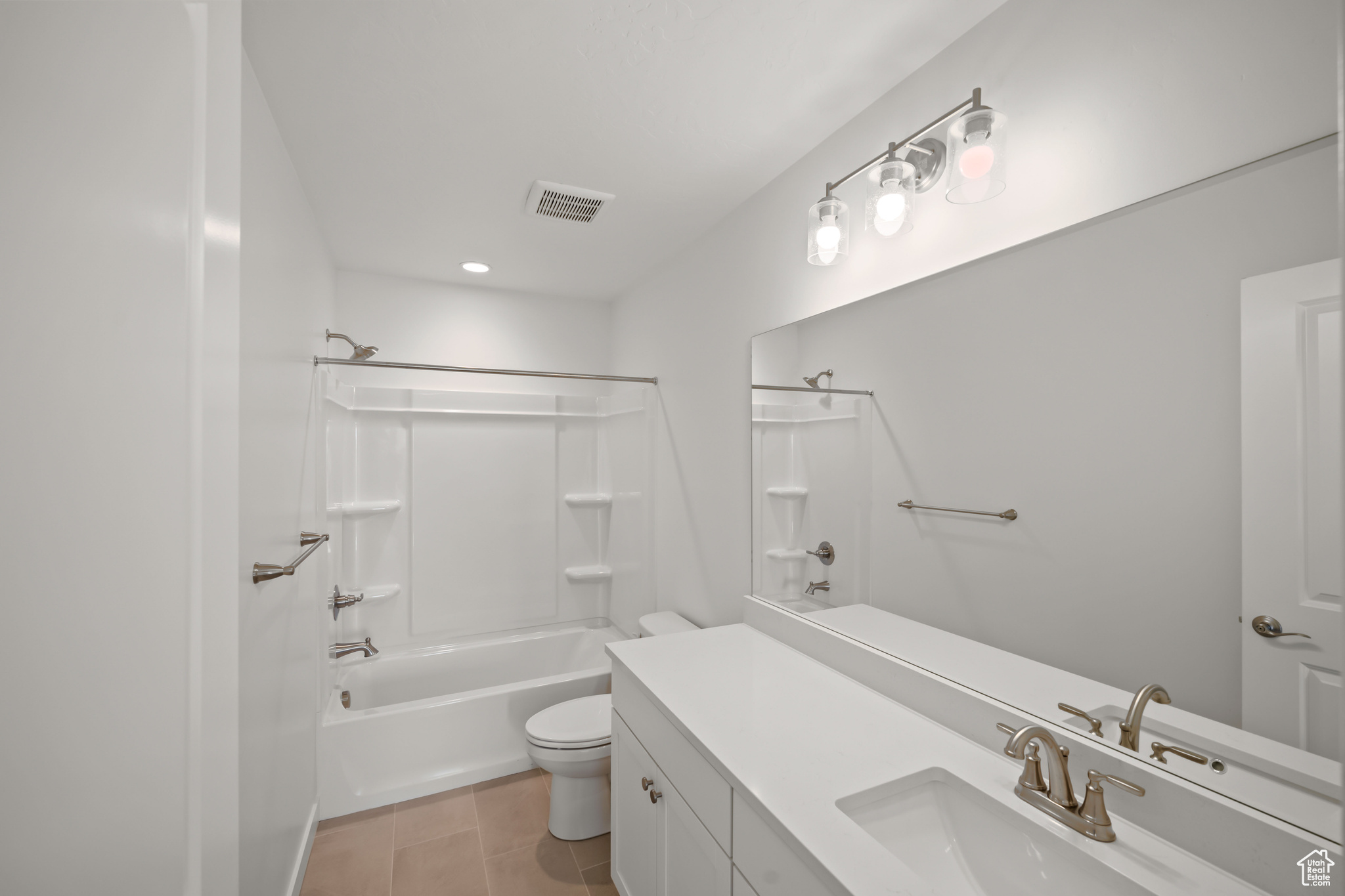 Full bathroom featuring tile patterned floors, vanity, toilet, and washtub / shower combination