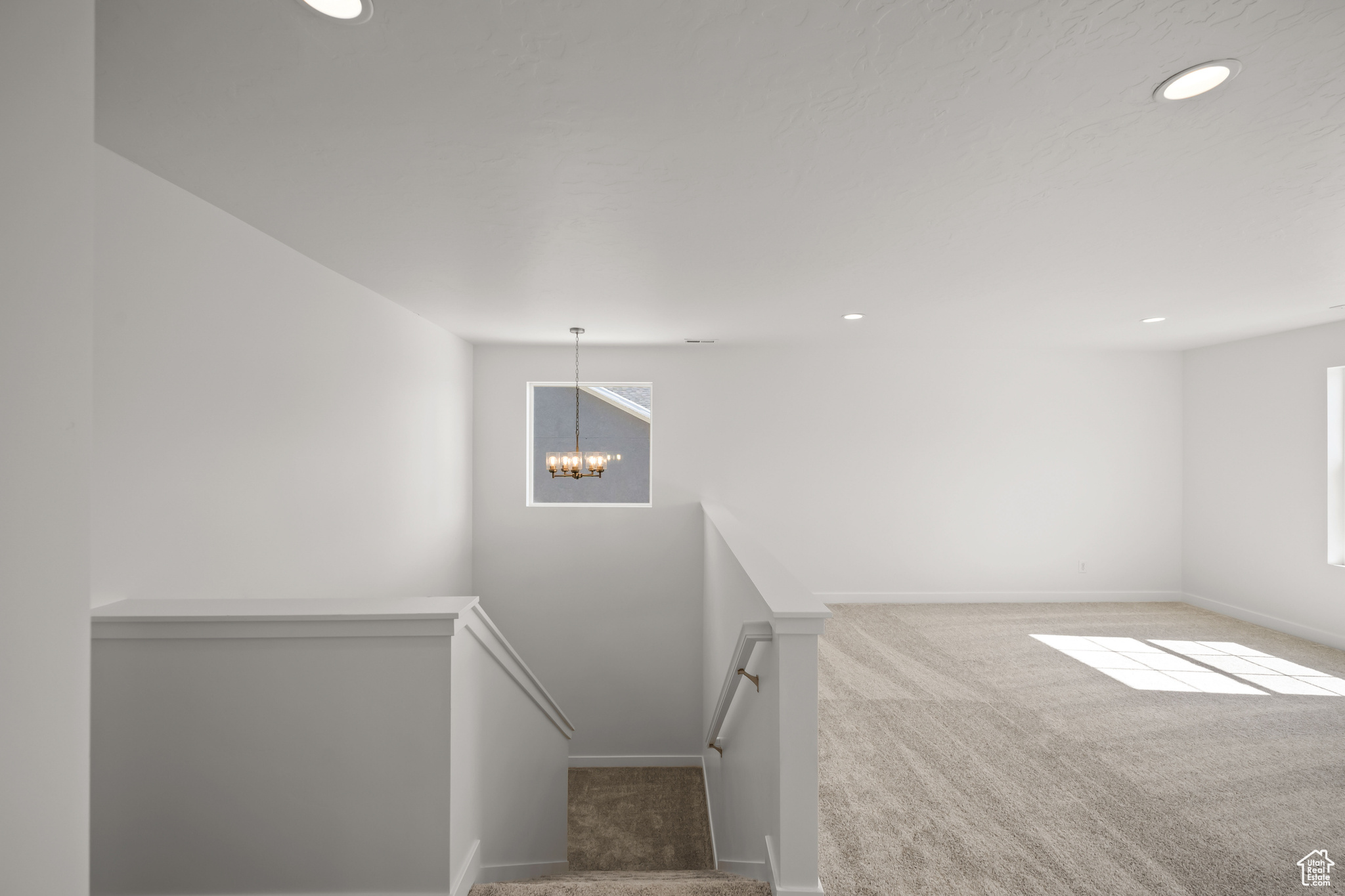 Staircase featuring a chandelier and carpet flooring