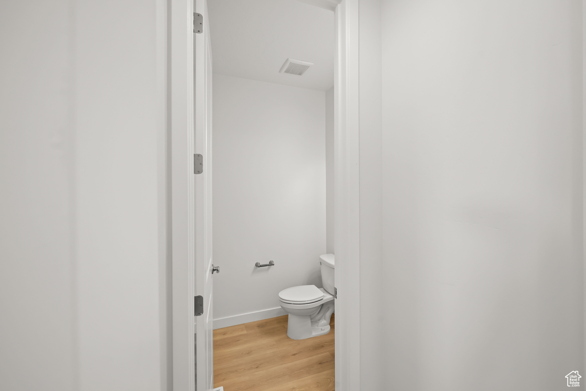 Bathroom featuring wood-type flooring and toilet