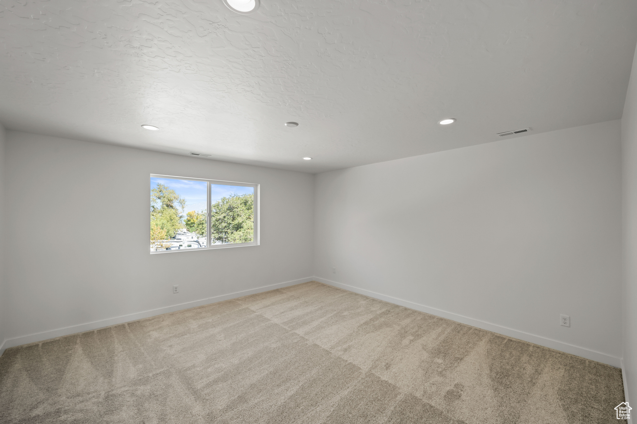 Empty room with light colored carpet