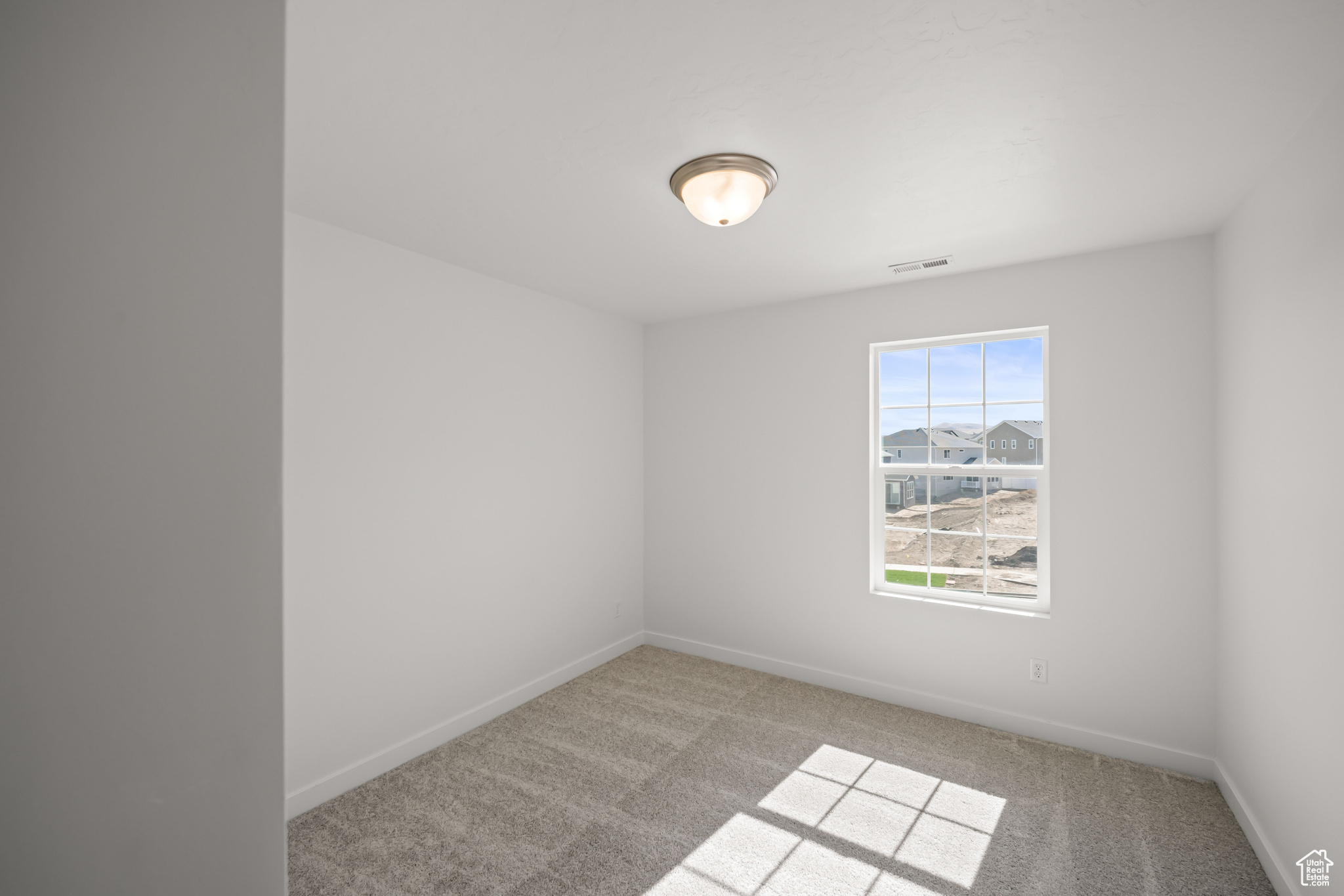 Spare room featuring light carpet