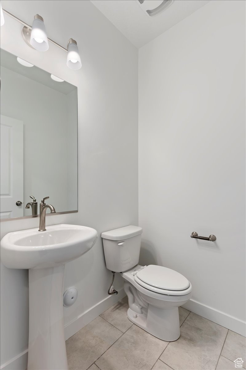 Bathroom featuring sink, tile patterned flooring, and toilet