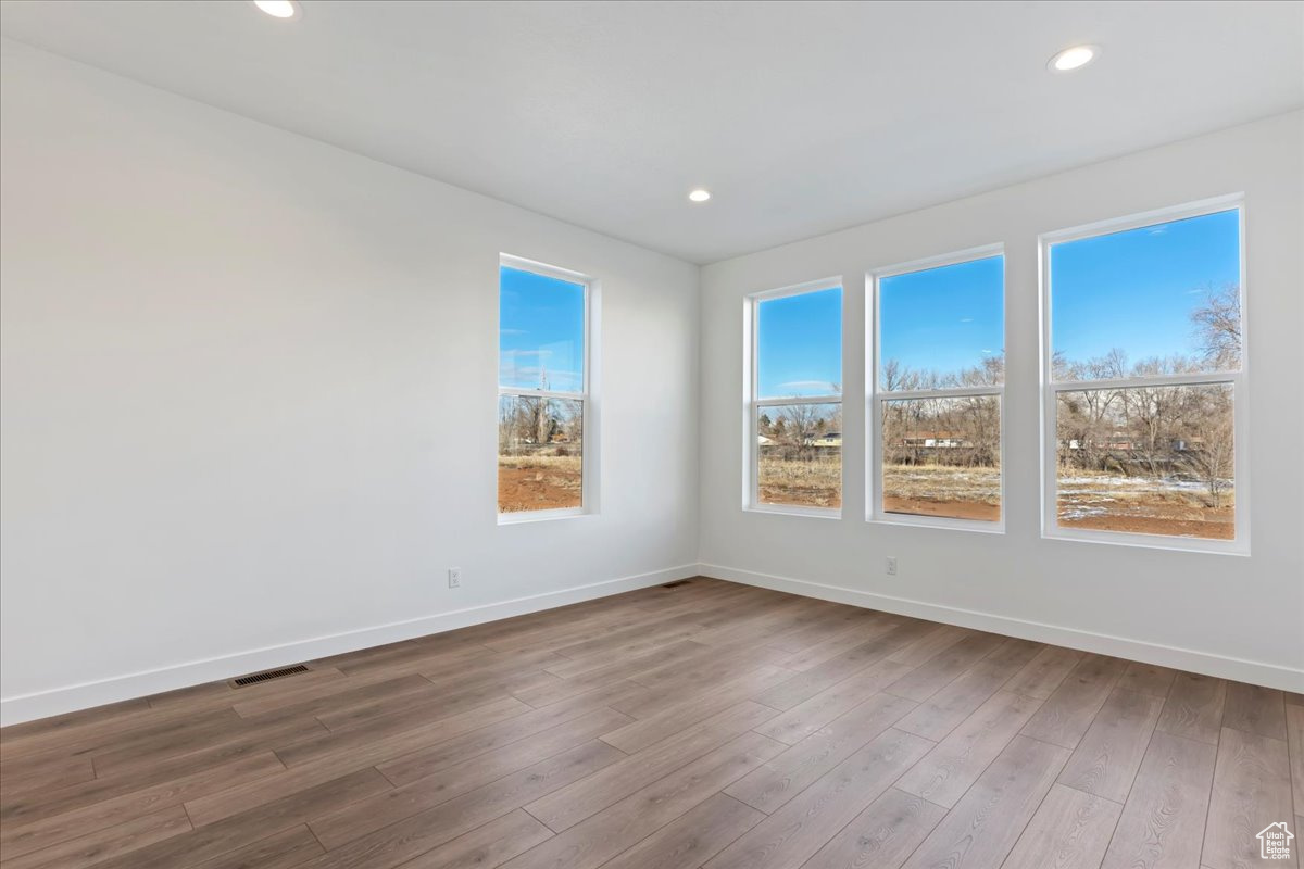 Empty room with hardwood / wood-style floors