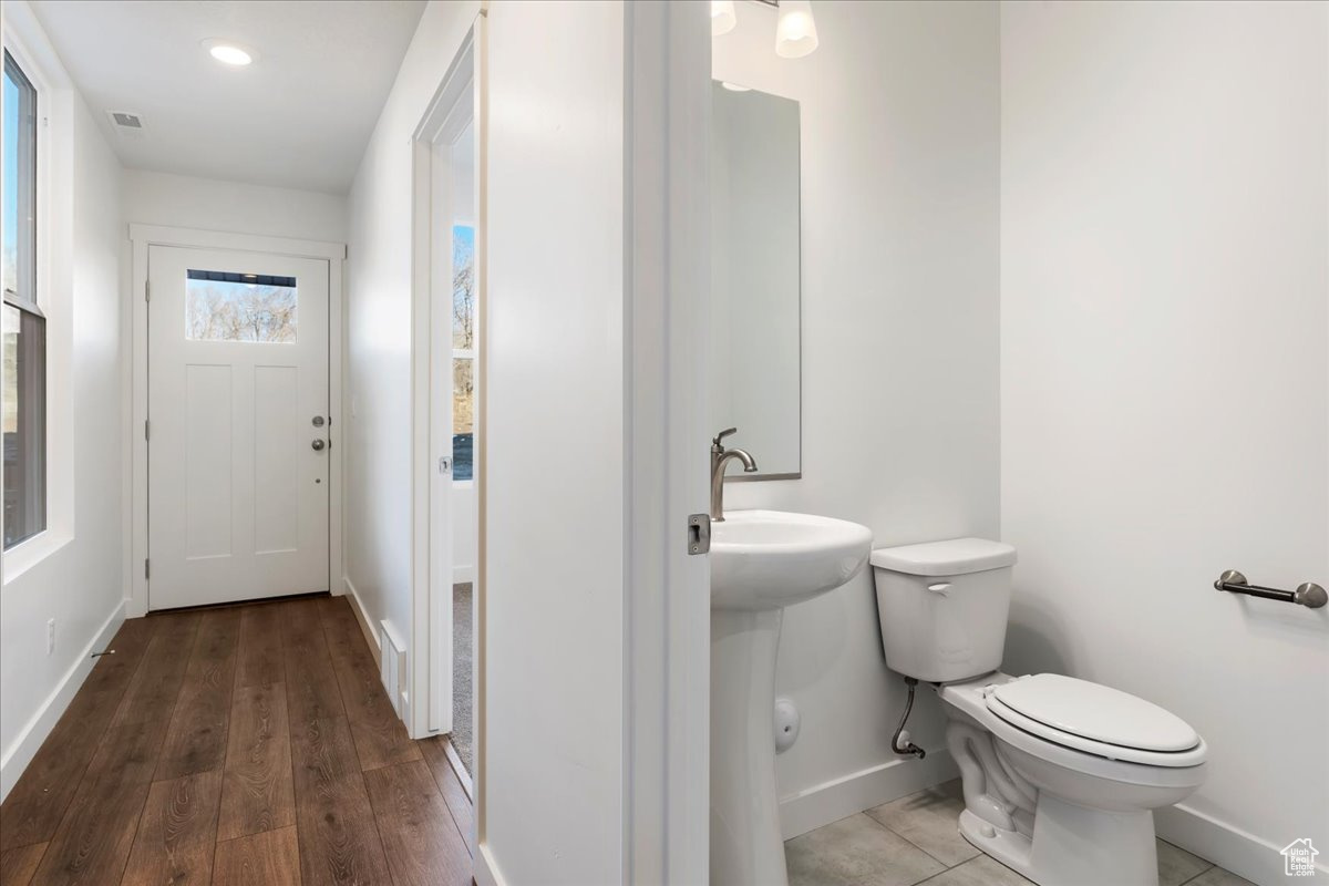 Bathroom featuring wood-type flooring and toilet