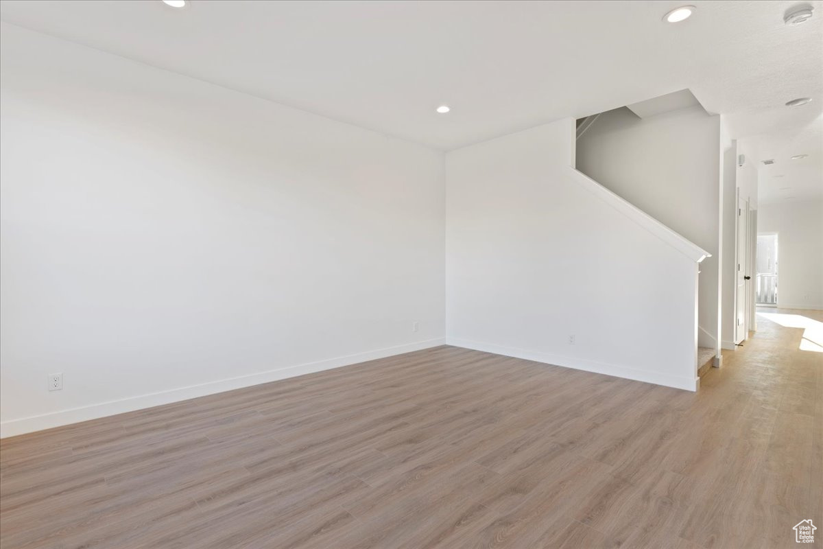 Empty room with light hardwood / wood-style flooring