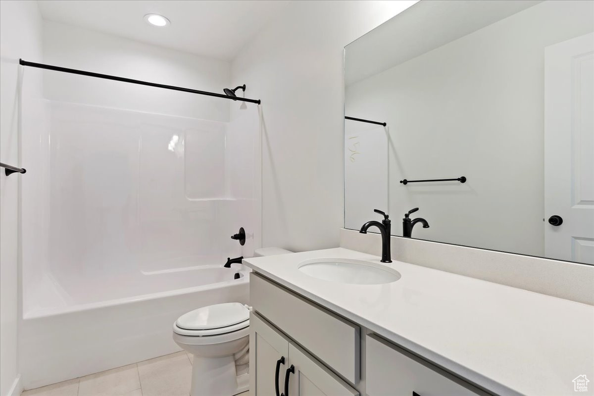 Full bathroom with tile patterned flooring, vanity, shower / bathtub combination, and toilet