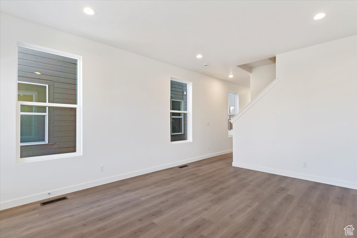 Empty room with hardwood / wood-style floors