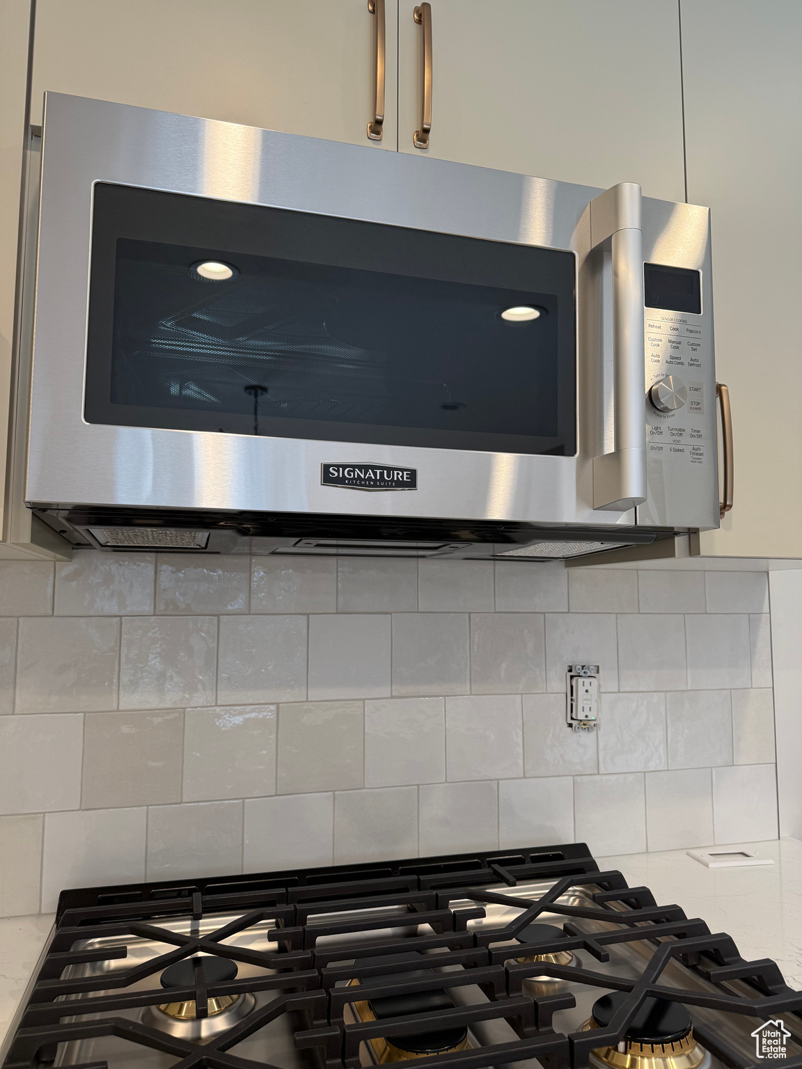 Room details featuring gas stovetop, light stone countertops, and tasteful backsplash