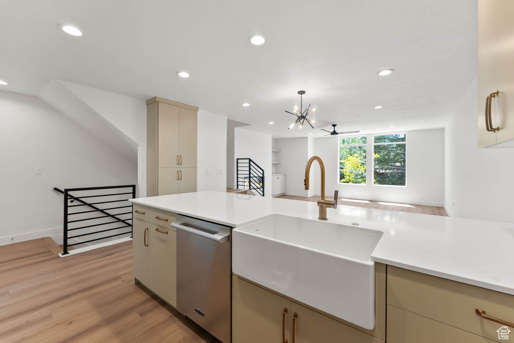 Kitchen with pendant lighting, dishwasher, cream cabinets, ceiling fan with notable chandelier, and Farm sink