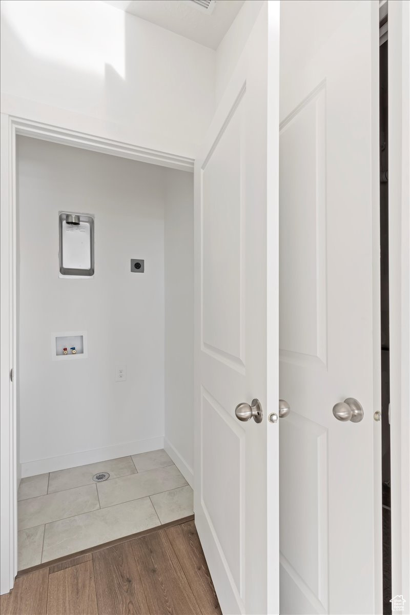 Washroom with hookup for a washing machine, wood-type flooring, and hookup for an electric dryer