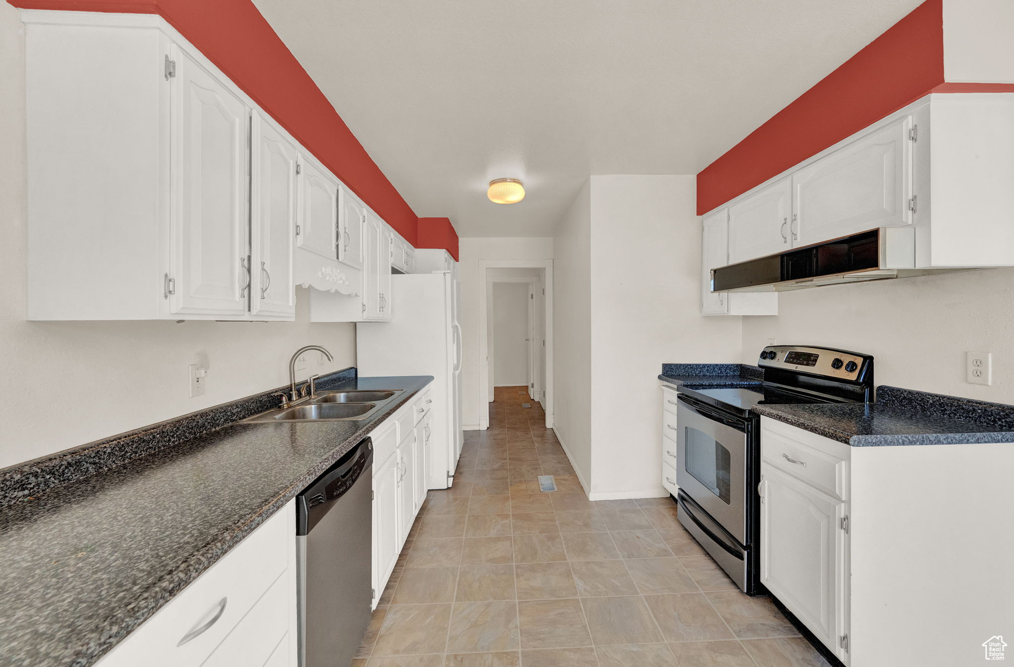 Kitchen featuring white cabinets, stainless steel appliances, and sink