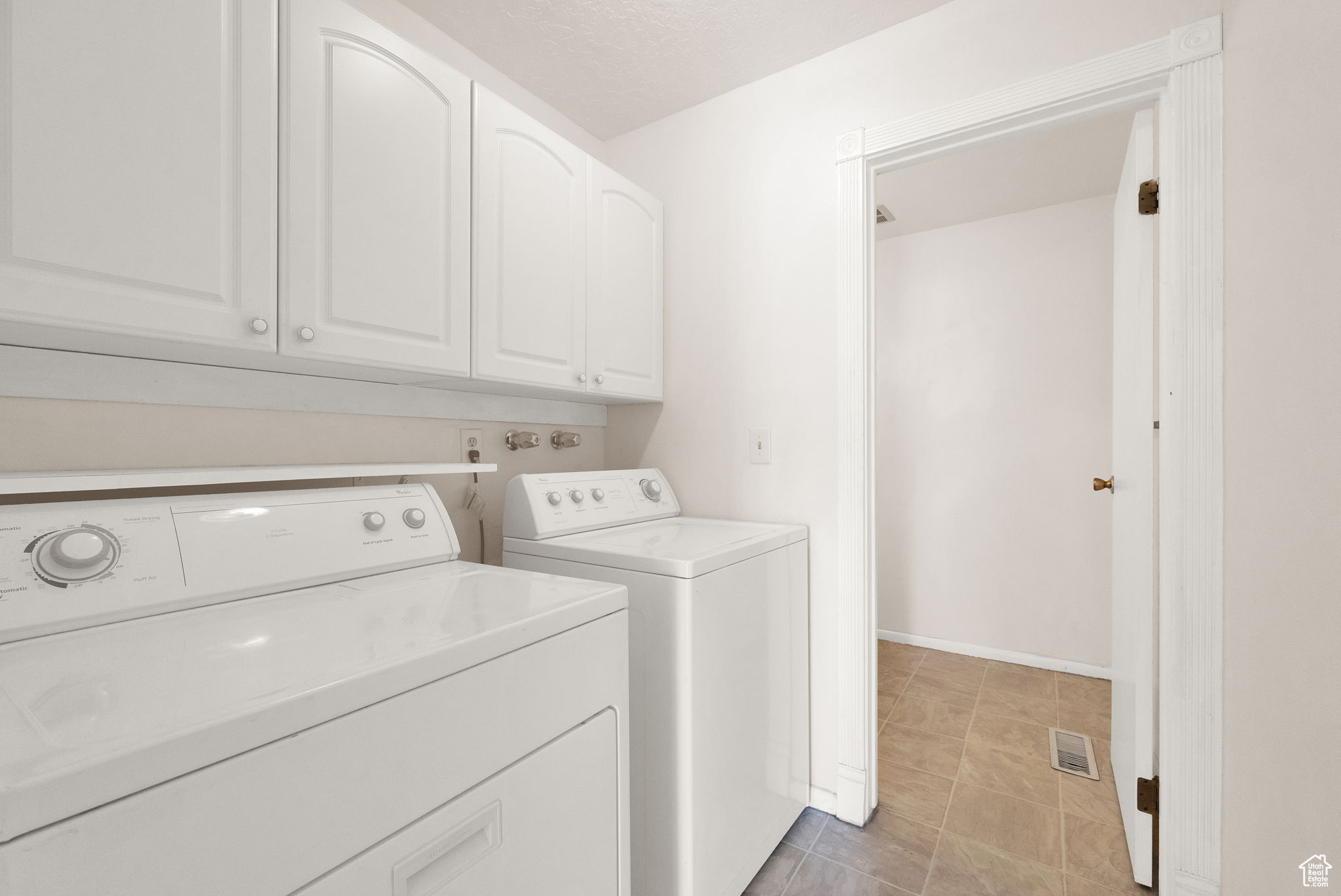 Clothes washing area with cabinets and washer and dryer