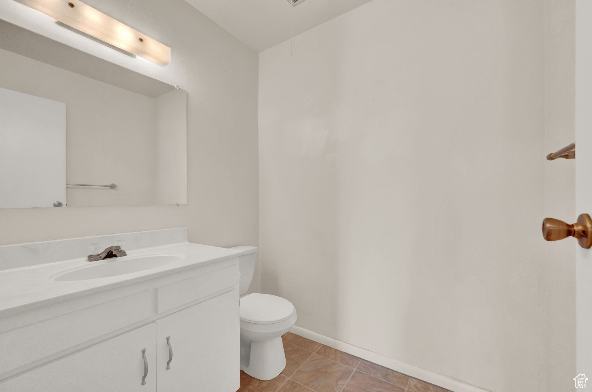 Bathroom featuring tile patterned floors, vanity, and toilet