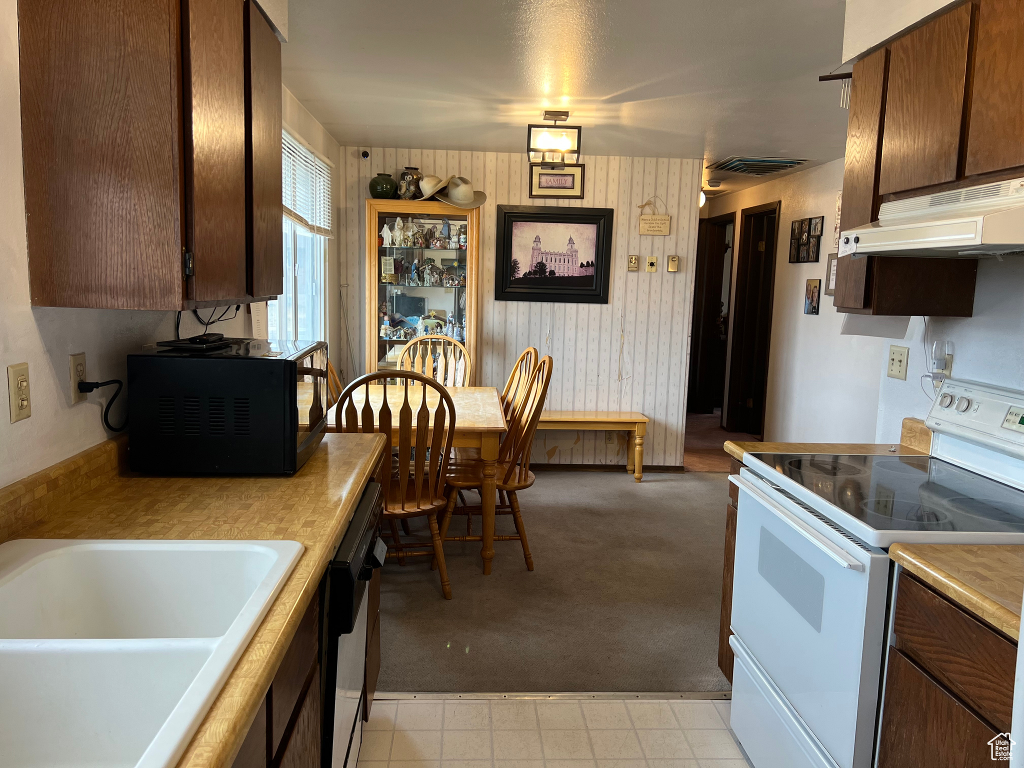 Kitchen featuring black dishwasher, sink, and electric stove