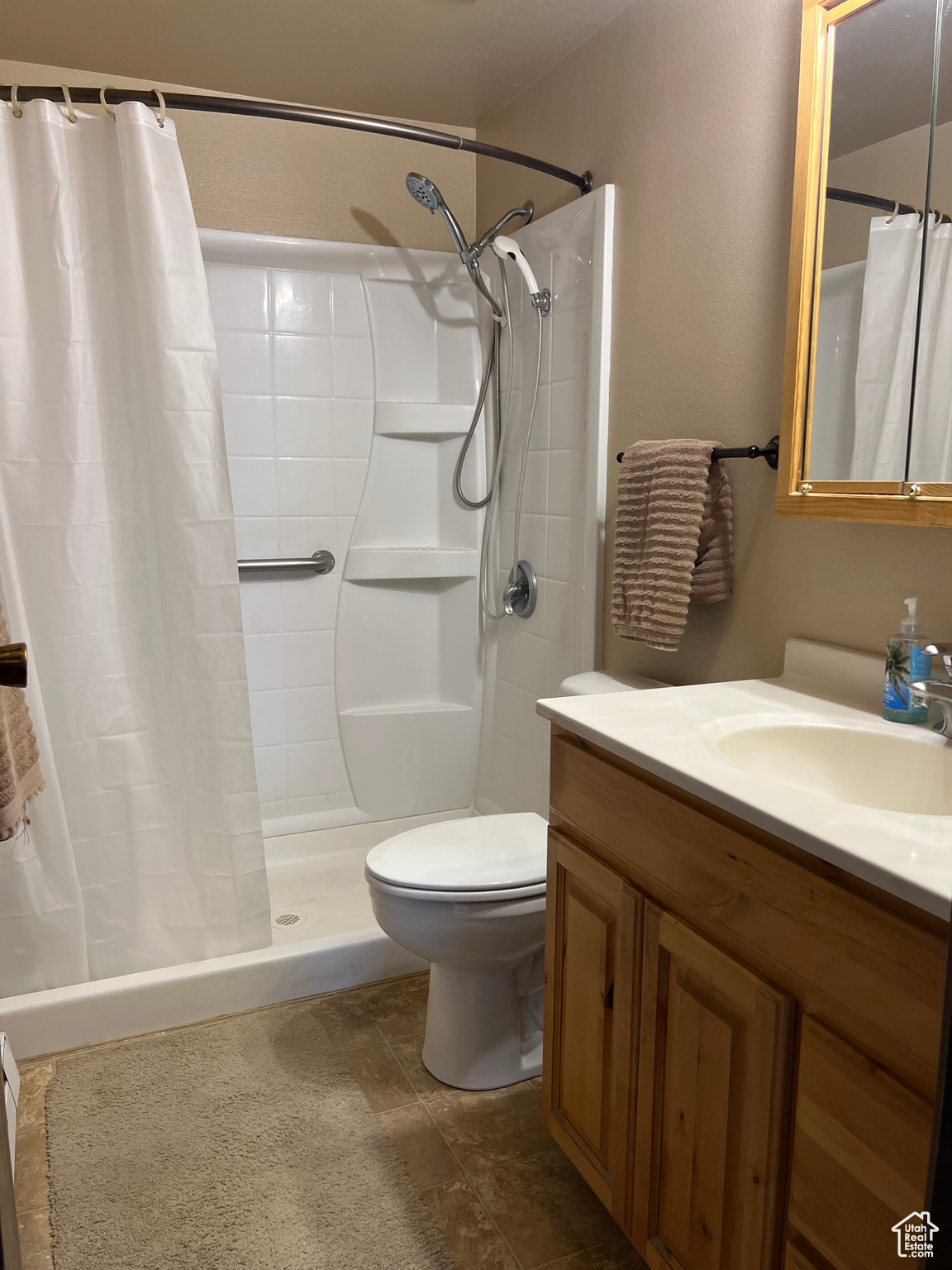 Bathroom with a shower, vanity, and toilet