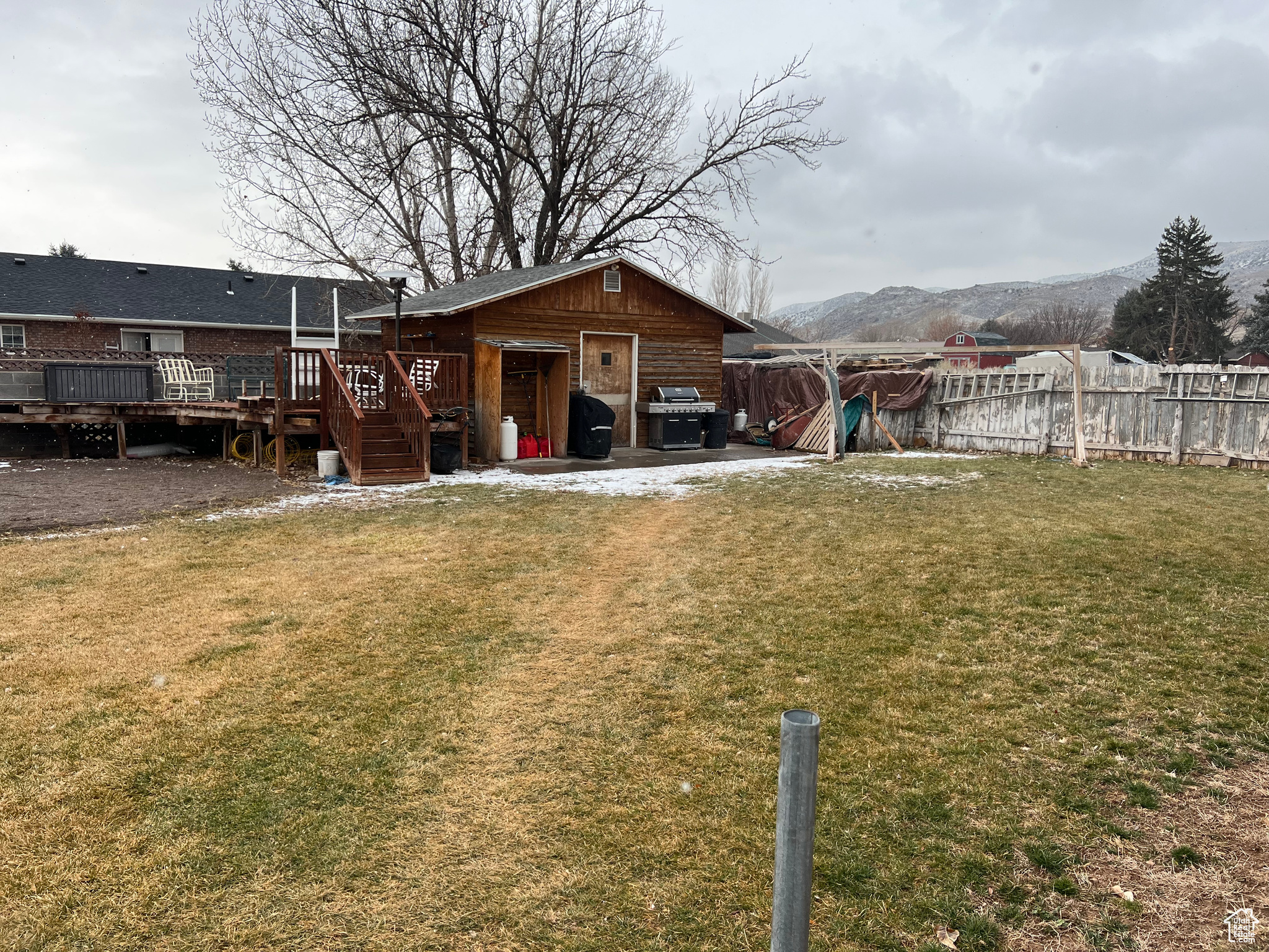 View of yard with a deck with mountain view and an outbuilding