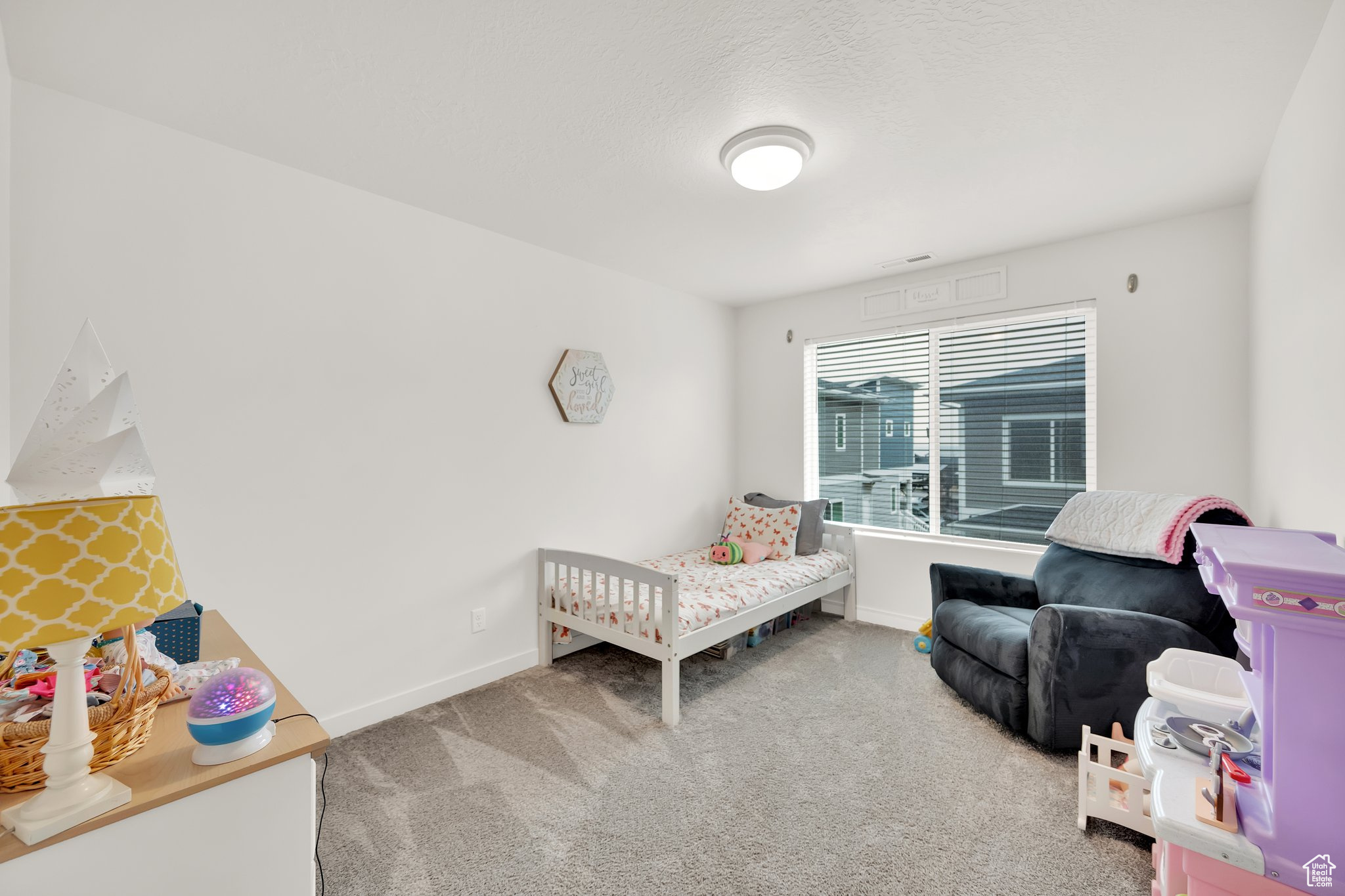 Bedroom with carpet and a nursery area