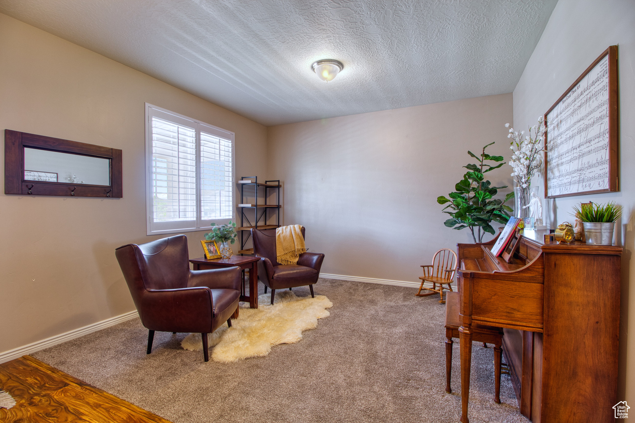 Living area featuring carpet and a textured ceiling