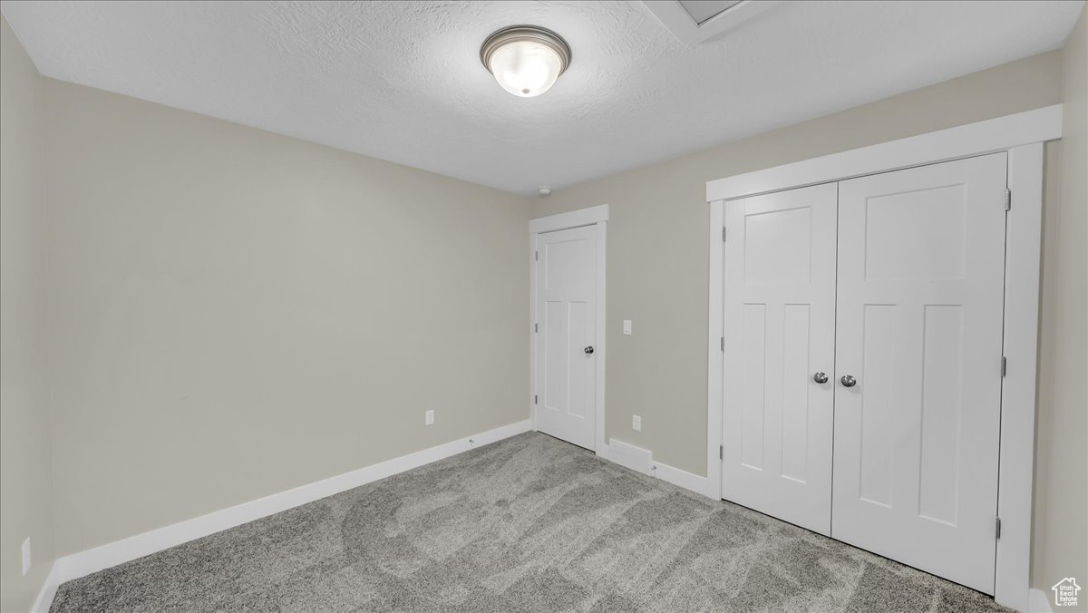 Bedroom featuring a closet, carpet floors, and a textured ceiling