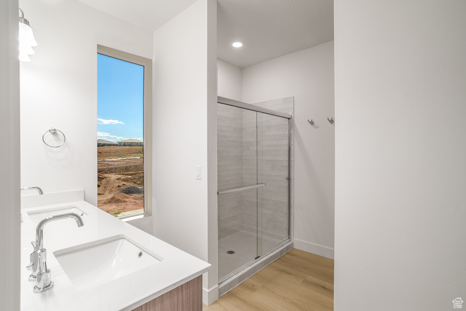 Bathroom featuring 100% waterproof laminate, vanity, and an enclosed shower