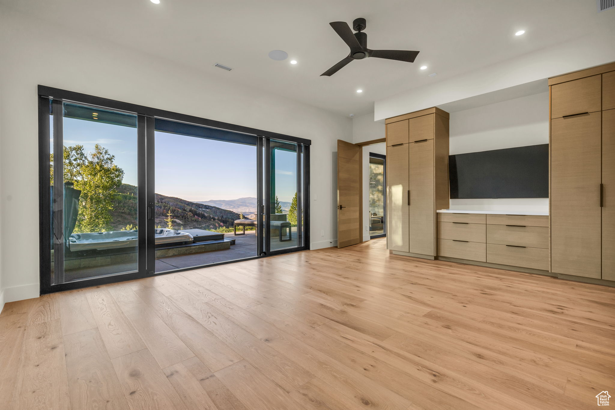 Unfurnished living room with ceiling fan and light hardwood / wood-style floors