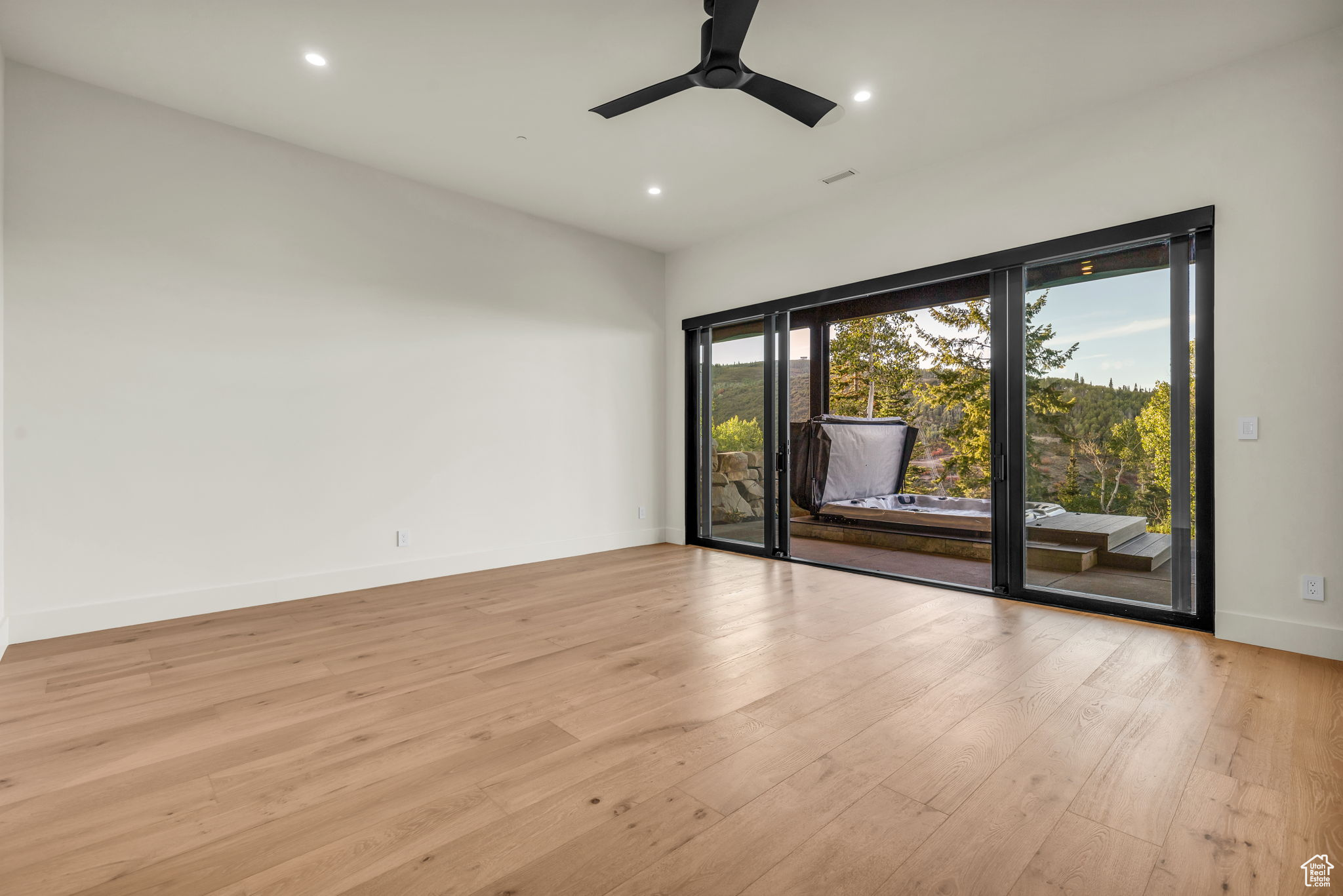 Empty room with light hardwood / wood-style floors and ceiling fan