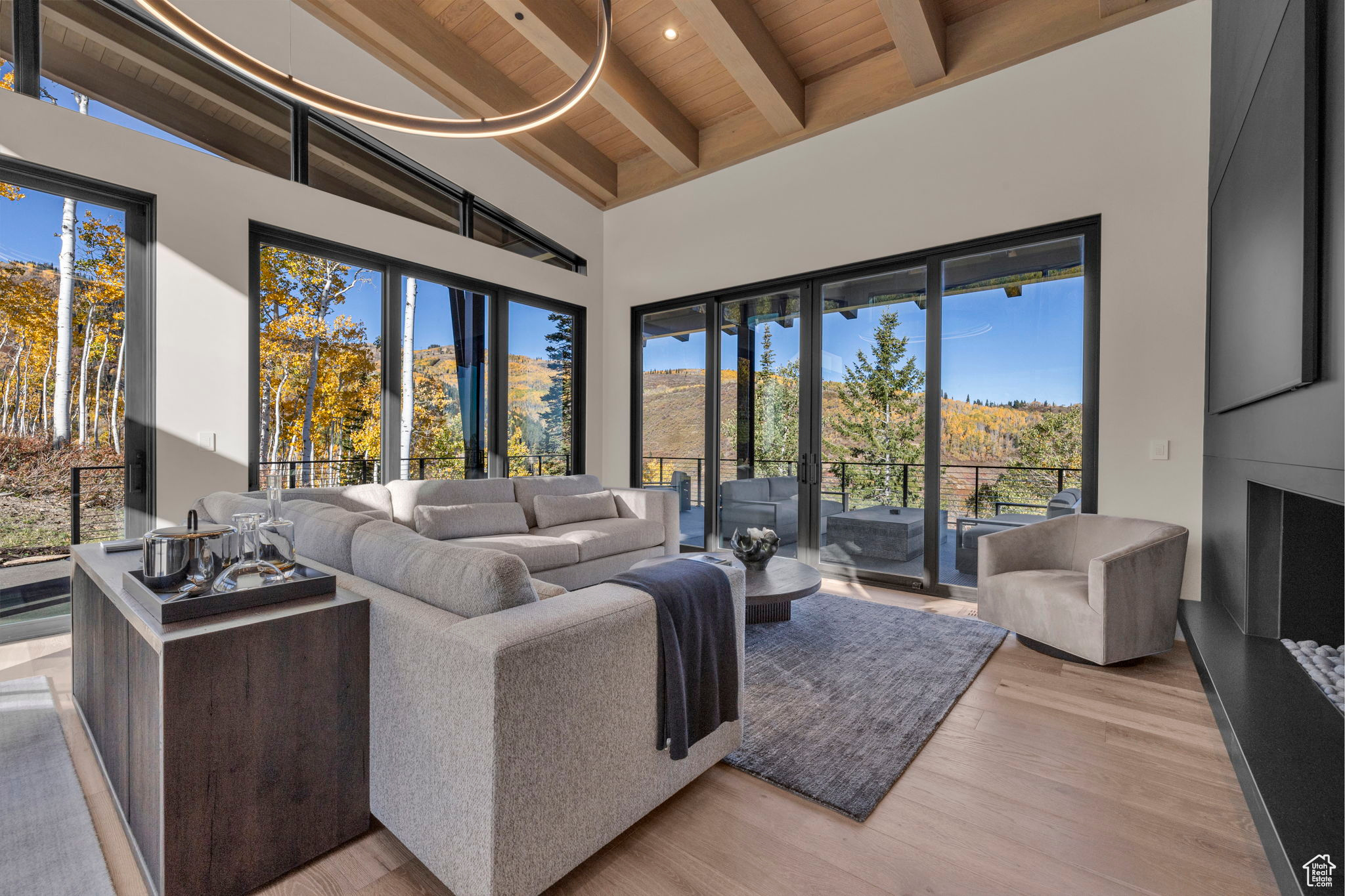 Living room with beamed ceiling, light wood-type flooring, wooden ceiling, and high vaulted ceiling